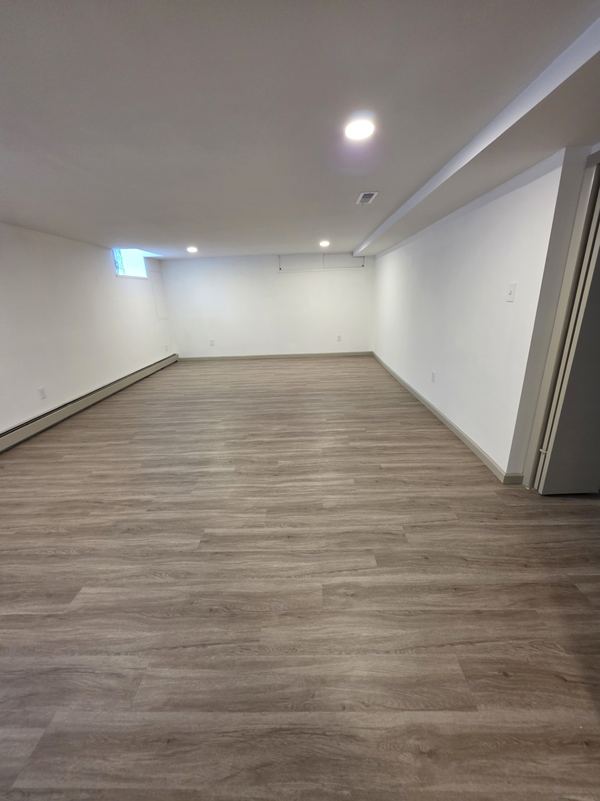 Finished basement with recessed lighting and vinyl plank floor
