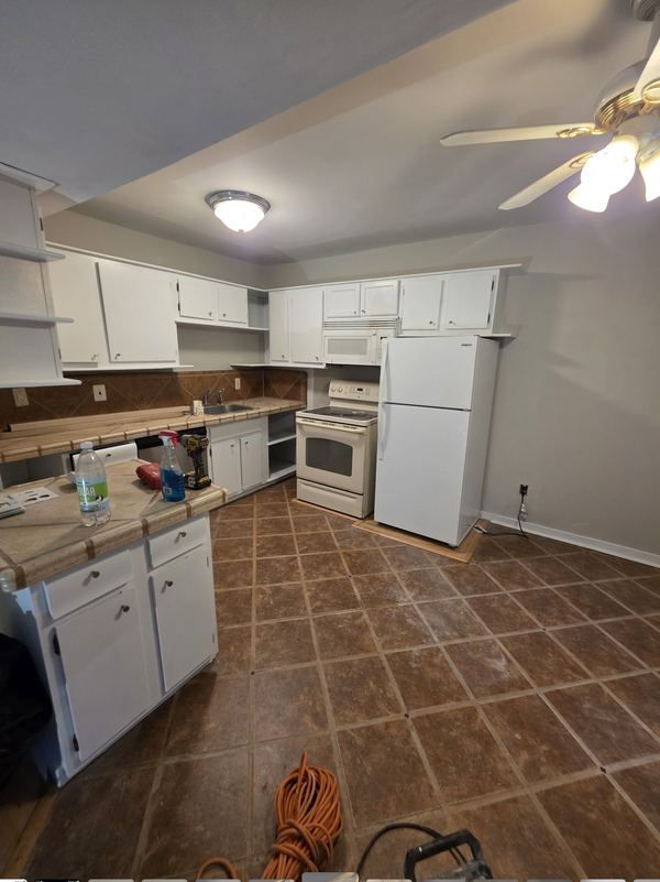 Same kitchen after cabinets were refinished white