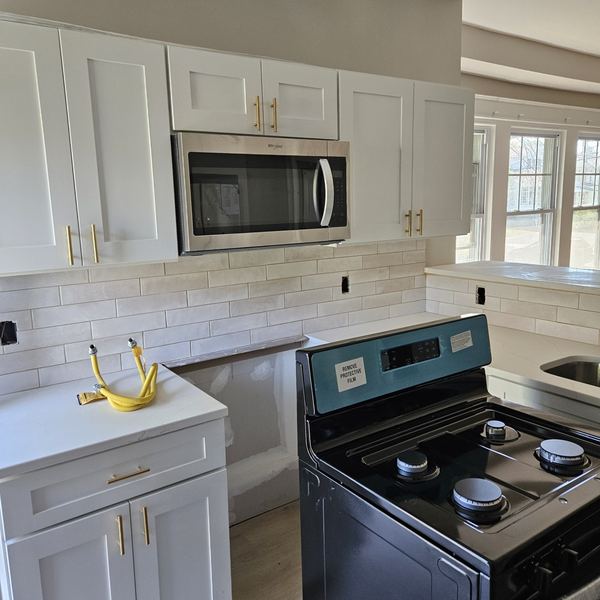 Rowhome kitchen with subway tile and white shaker cabinets